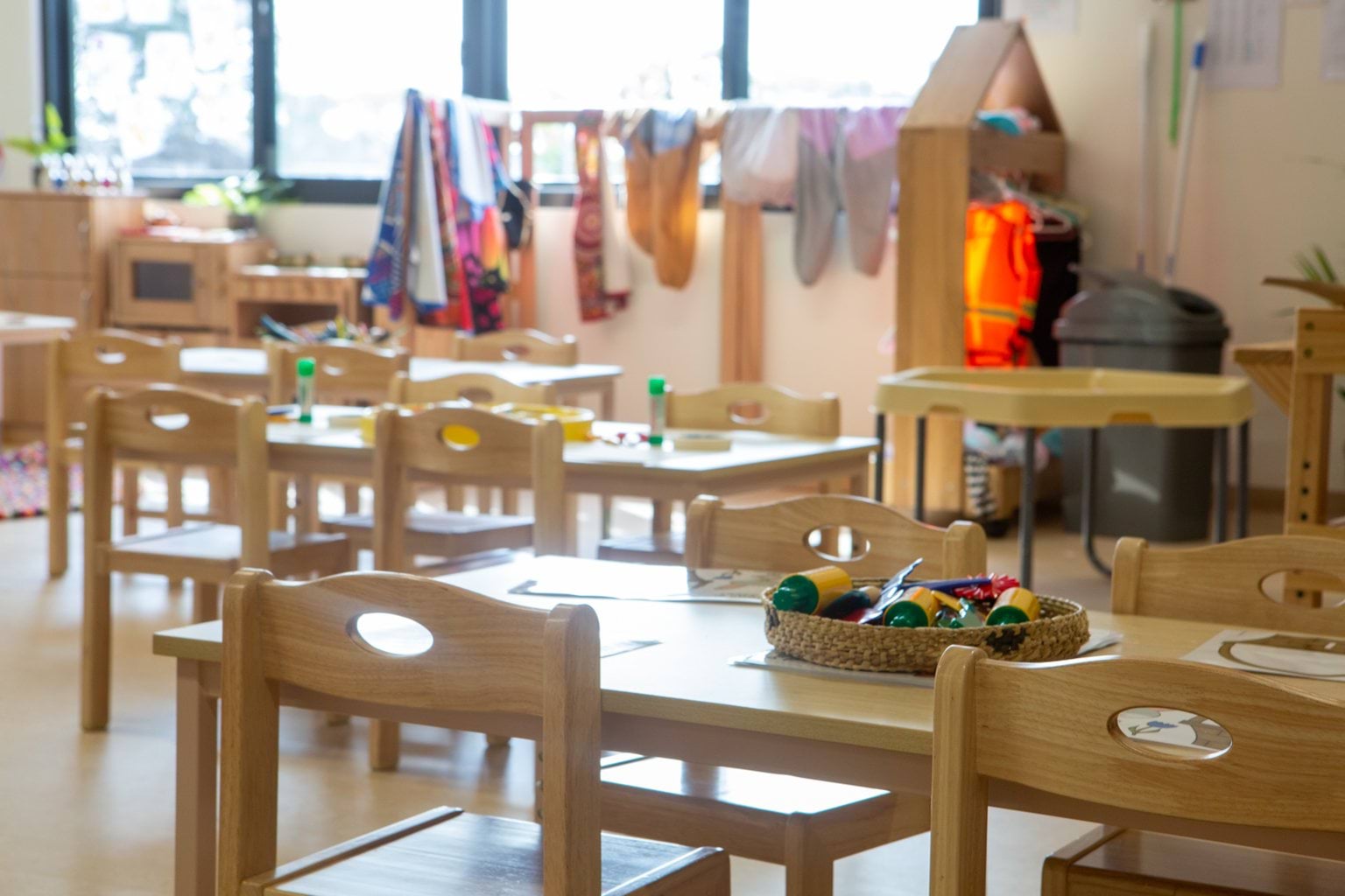 Close-up of wooden tables and chairs at Early Learning Victoria Bani Walup (Murtoa), toys softly blurred in background.