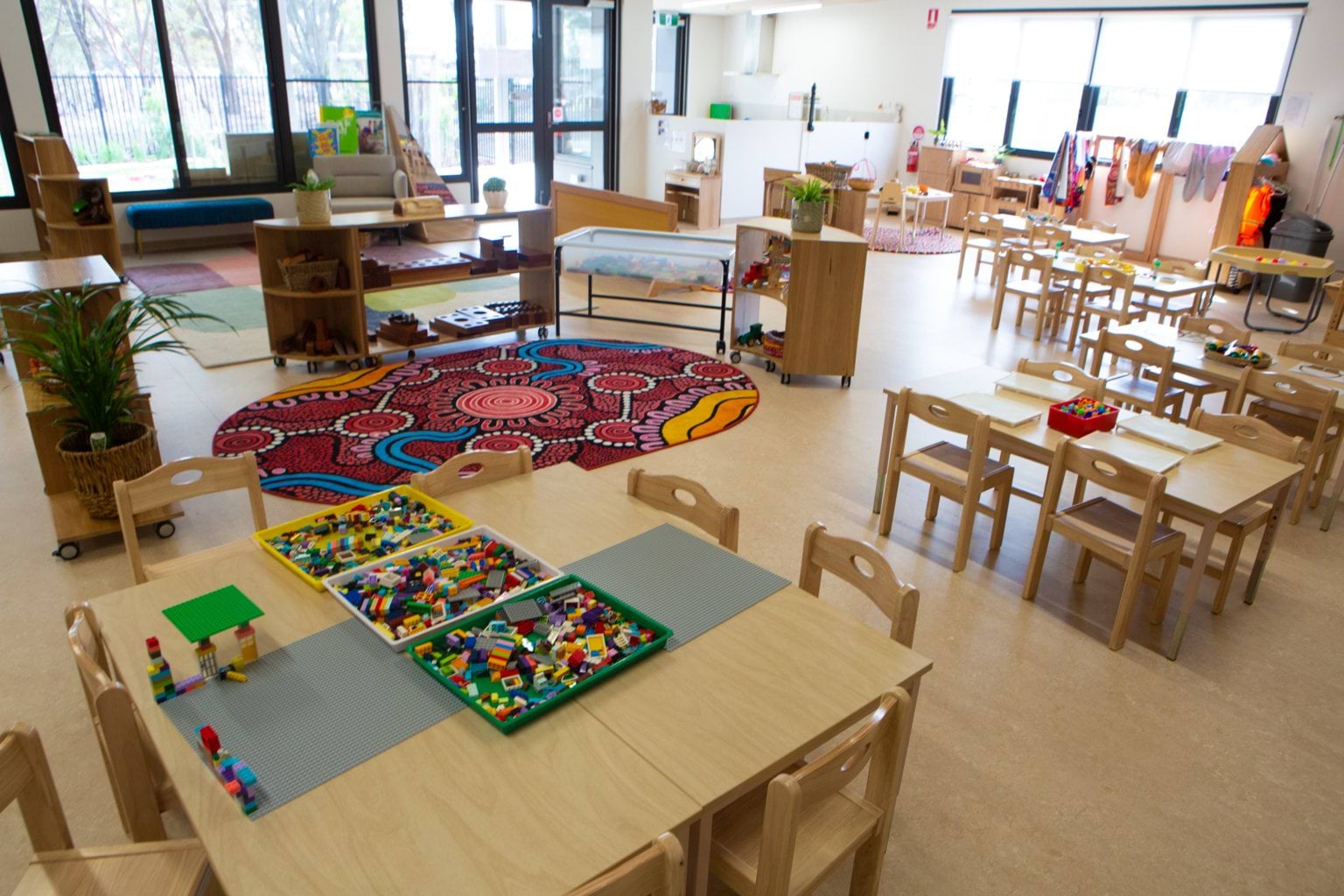 Interior of Early Learning Victoria Bani Walup (Murtoa) with wooden furniture, educational toys, large windows and Aboriginal dot art rug.