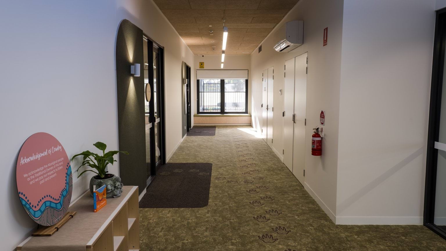 Interior view of hallway at Early Learning Victoria Muyan centre, with an Acknowledgement of Country sign in foreground.